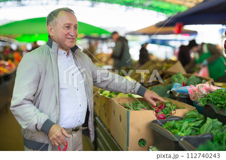 Middle aged man buying radish Middle aged man buying radish 112740243