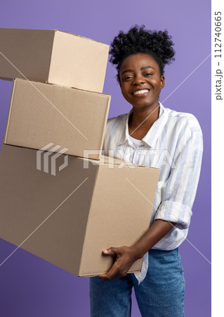 Dark-skinned young woman with boxes in hands looking contented 112740665