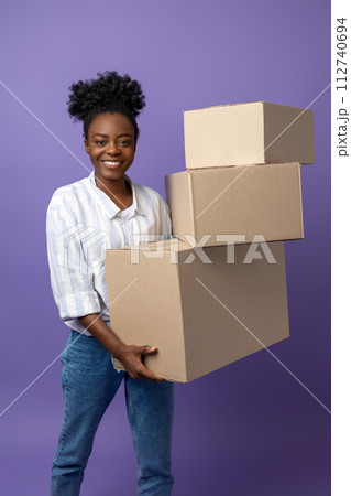 Dark-skinned young woman with boxes in hands looking contented 112740694