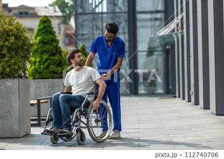 Brunette male nurse rolling a wheelchair with a patient Brunette male nurse rolling a wheelchair with a patient 112740706
