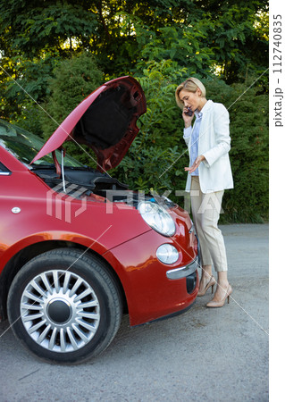 Young woman using mobile phone for calling to service for repairing her car Young woman using mobile phone for calling to service for repairing her car 112740835