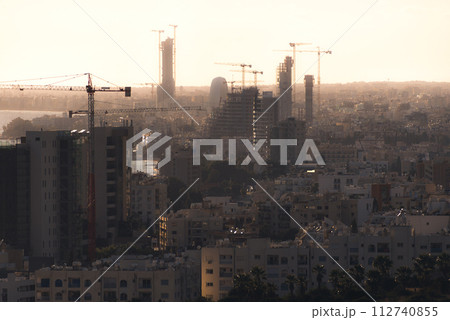 Silhouettes of high-rise buildings under construction in evening. Limassol, Cyprus Silhouettes of high-rise buildings under construction in evening. Limassol, Cyprus 112740855