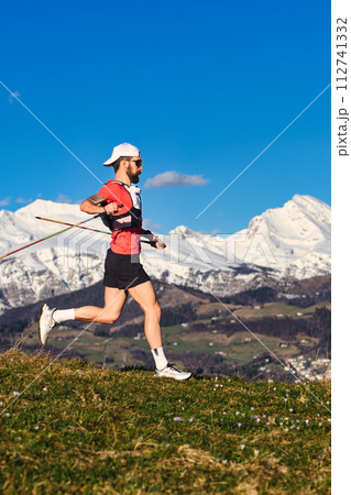 Sporty man practices nordic walking in the hills Sporty man practices nordic walking in the hills 112741332