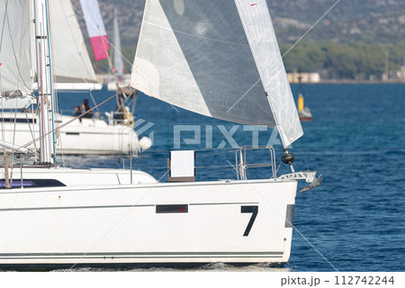 Sailing yachts with white sails in the sea Sailing yachts with white sails in the sea 112742244
