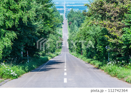 夏の北海道　人気の観光名所　快晴の天に続く道 112742364