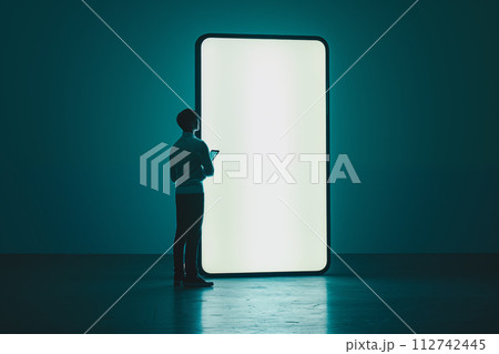 巨大なスマートフォンの前で考える男性 巨大なスマートフォンの前で考える男性 112742445