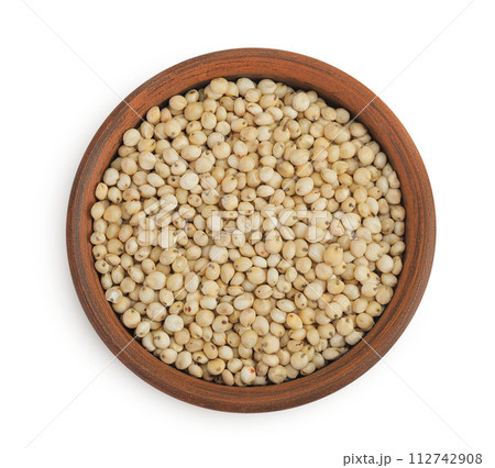 Sorghum seeds in ceramic bowl isolated on white background. Top view. Flat lay. 112742908