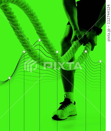 Cropped image of muscular man training with rope against monochrome green background with abstract element. 112744124