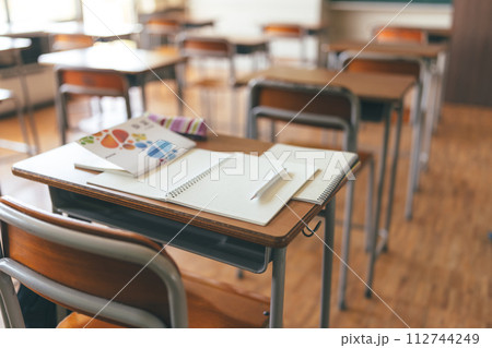 教室の机に置かれた教科書やノート 112744249