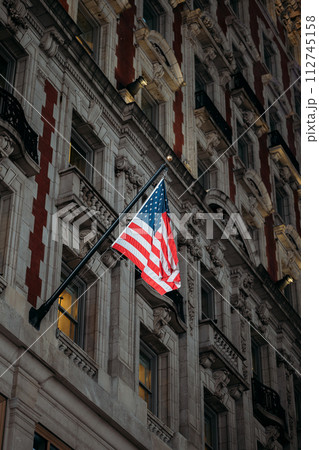 Proud American Flag Hanging from Traditional New York Architecture Proud American Flag Hanging from Traditional New York Architecture 112745158