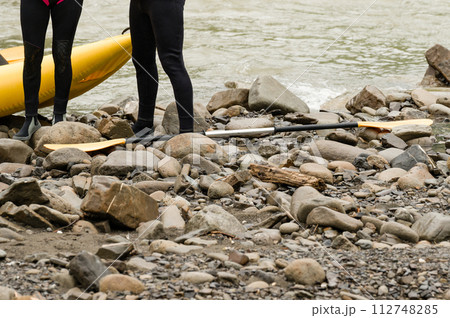 People are preparing for rafting. The athlete is waiting for the team on the bank of the river. People are preparing for rafting. The athlete is waiting for the team on the bank of the river. 112748285