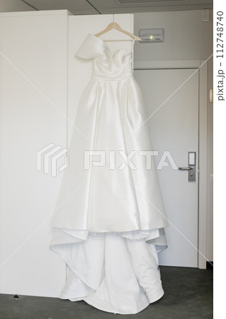 the bride's wedding dress hangs on the closet in the morning room the bride's wedding dress hangs on the closet in the morning room 112748740