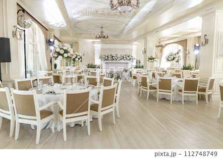 Elegant wedding reception venue with sophisticated decor and floral arrangements Elegant wedding reception venue with sophisticated decor and floral arrangements 112748749