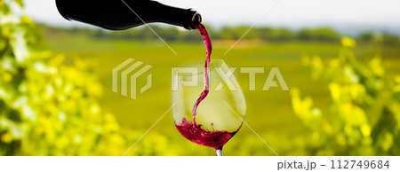 Wine glass with pouring red wine Wine glass with pouring red wine 112749684