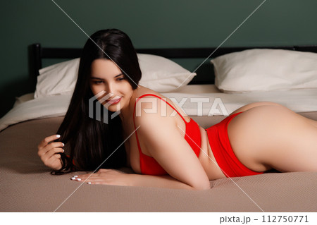 Beautiful sexy woman in black lingerie lying on 112750771