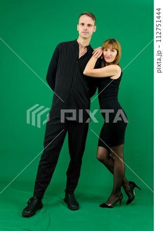 Beg squat look into the eyes stretch hands there desire to dance girl invites a man to dance on a green background makes eyes denim clothes chromakey bring time with me love. relationship 112751444