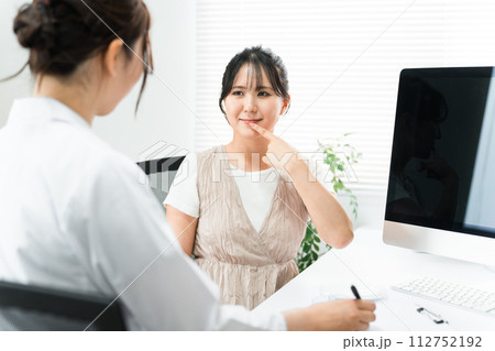 唇・口元の悩み・病気で診察を受ける患者の女性と医師（ヘルペス・口角炎・口唇炎・口内炎） 112752192