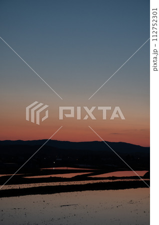 美しい春の夕暮と水を張った水田 112752301
