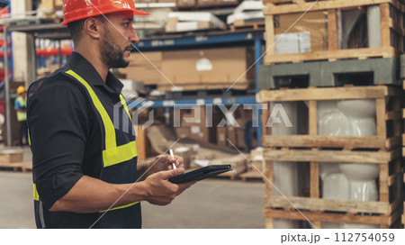 Hispanic men hands touch smart tablet Warehouse management logistics counting checking products on inventory shelf. Engineer Man hands worker check stock control in distribution storage checklist 112754059