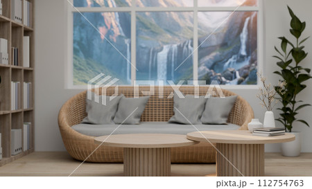 A comfortable, Scandinavian living room features a wooden coffee table and a wicker couch A comfortable, Scandinavian living room features a wooden coffee table and a wicker couch 112754763