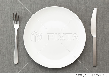 ランチョンマットに白い皿とカトラリー ランチョンマットに白い皿とカトラリー 112754840