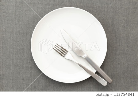 ランチョンマットに白い皿とカトラリー 112754841