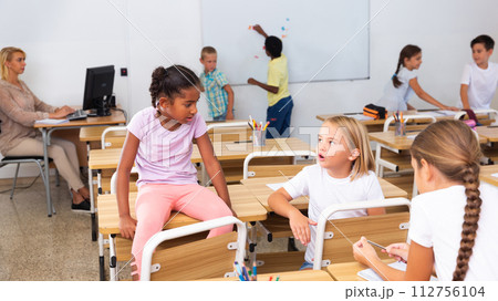 Tween boys and girls friendly talking in break in classroom 112756104