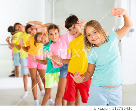 Group of children rehearsing movements of ballet in classroom 112756436
