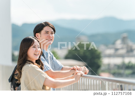 屋上で街・景色を眺める学生・大学生の男女カップル 屋上で街・景色を眺める学生・大学生の男女カップル 112757108