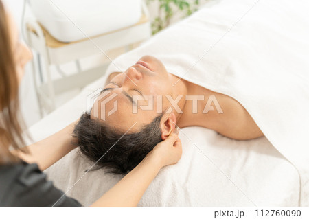 メンズエステサロンでフェイシャルエステの施術を受ける男性 112760090