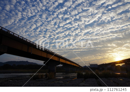 鉄橋にさす朝日 112761245
