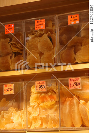 香港・徳輔道西の高級乾物店で売られる魚の高級食材の浮き袋（魚膠）の上で店番をするネコ 112762884
