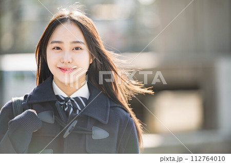 カメラ目線ではにかんでいる女子高生 112764010