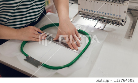 girl seamstress doing embroidery puts fabric in a special hoop, hobby and work from home girl seamstress doing embroidery puts fabric in a special hoop, hobby and work from home 112764508