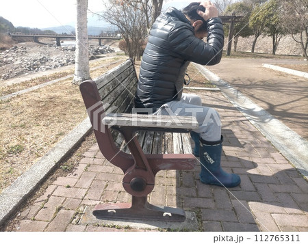 頭を抱える男性 112765311