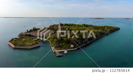 Aerial view of the plagued ghost island of Poveglia in the Venetian lagoon, opposite Malamocco along the Canal Orfano near Venice, Italy. Aerial view of the plagued ghost island of Poveglia in the Venetian lagoon, opposite Malamocco along the Canal Orfano near Venice, Italy. 112765614