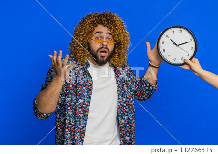 Stylish man with anxiety checking time on clock, running late to work, being in delay, deadline 112766315