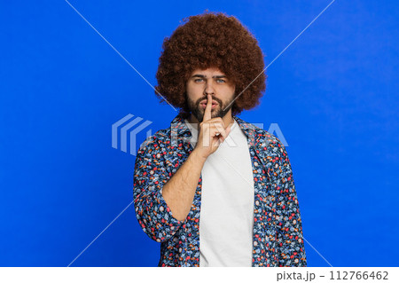 Young man presses finger to lips make silence gesture sign do not tells secret stop gossip privacy 112766462