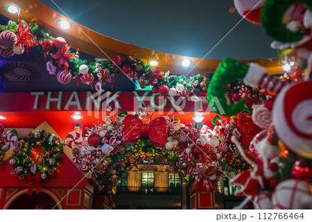 A warmly lit Christmas arch with THANK YOU in the center, adorned with candy canes, holly, and greenery, creates a festive atmosphere in London, UK, at night. 112766464