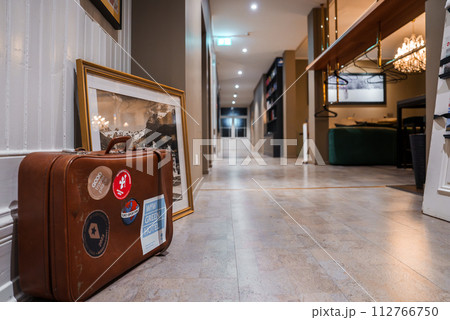 Luxurious hotel hallway in Engelberg with a vintage ski scene picture, a classic suitcase, and a modern chandelier, capturing the blend of history and contemporary elegance. Luxurious hotel hallway in Engelberg with a vintage ski scene picture, a classic suitcase, and a modern chandelier, capturing the blend of history and contemporary elegance. 112766750
