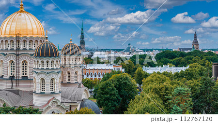 The Nativity of Christ Cathedral in Riga, Latvia. Byzantine-styled Orthodox cathedral, the largest in the Baltic region, with golden colored dome, polished gilded cupolas gleaming through the trees 112767120