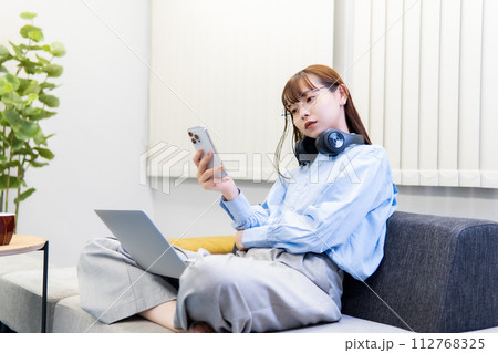 ノートパソコンで仕事をする/リモートワークをする女性 ノートパソコンで仕事をする/リモートワークをする女性 112768325