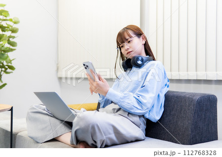 ノートパソコンで仕事をする/リモートワークをする女性 ノートパソコンで仕事をする/リモートワークをする女性 112768328