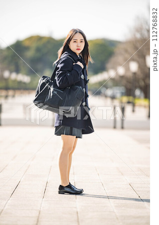 立ってカメラを見つめる女子高生と冬の街並み 立ってカメラを見つめる女子高生と冬の街並み 112768832