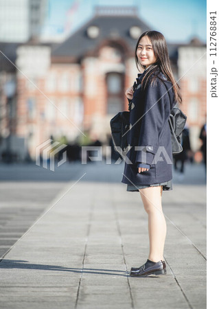 立ってカメラを見つめる女子高生と冬の街並み 立ってカメラを見つめる女子高生と冬の街並み 112768841