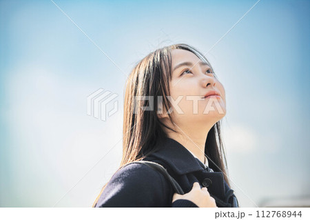 青空のもと未来を見据える女子高校生 112768944