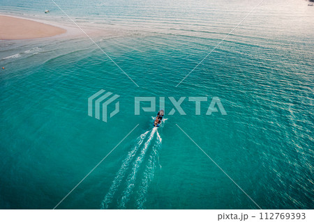 Boat on clear blue water on island 112769393