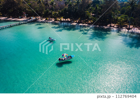 Boat on clear blue water on island 112769404