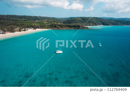 Boat floating on blue water at tropical island 112769409