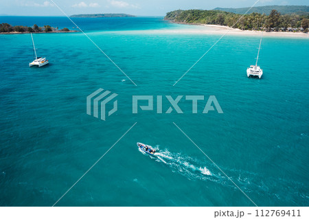 Boat floating on blue water at tropical island 112769411